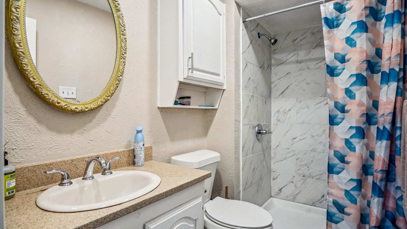 Bathroom with round mirror and tiled shower at Blue Ridge