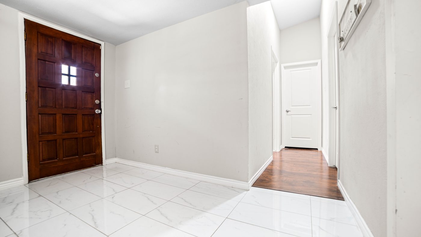 Tiled entry with wood front door at Chinaberry