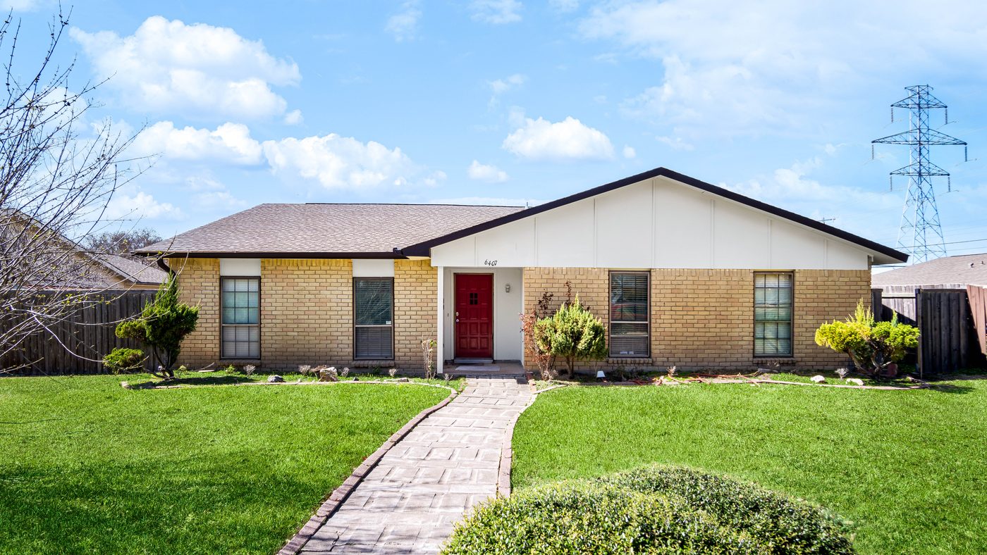 Brick front of Chinaberry with red door and paver walkway