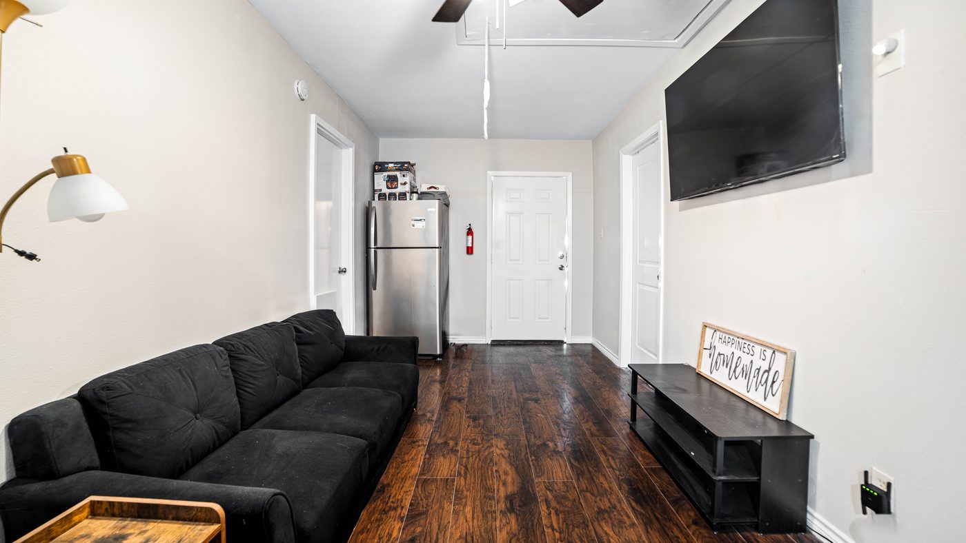 Living room with sofa and wall-mounted TV at Chinaberry