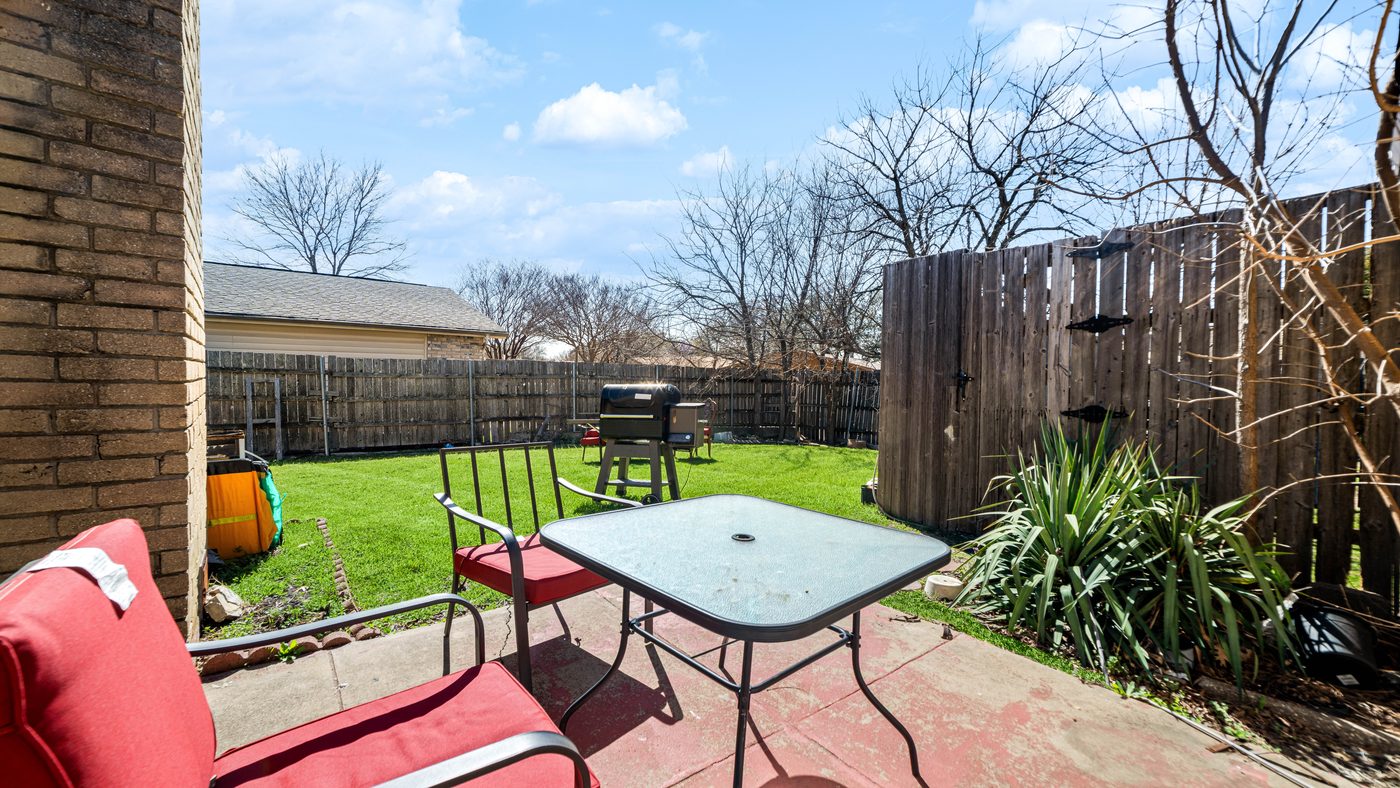 Brick patio with table and red chairs at Chinaberry