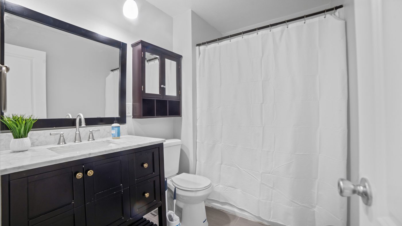 Bathroom with dark vanity and framed mirror at John Muir