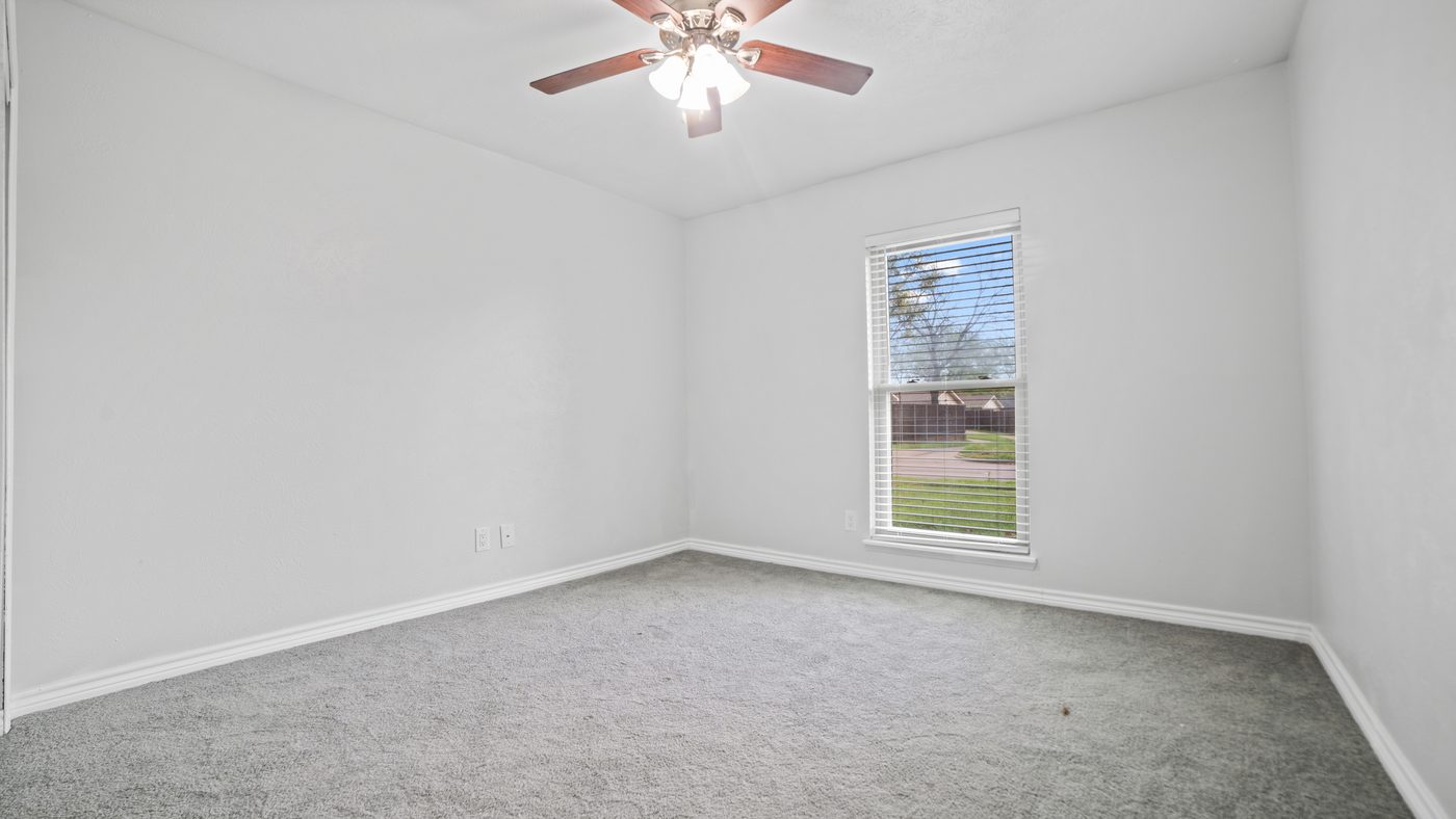 Carpeted bedroom with window and ceiling fan at John Muir