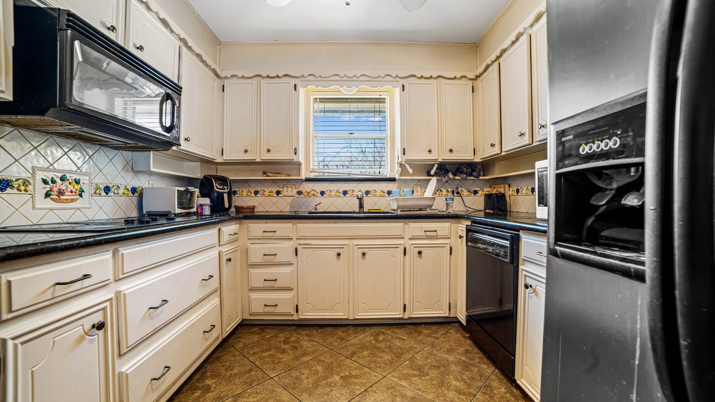 Kitchen with cream cabinets and tile backsplash at Papeete