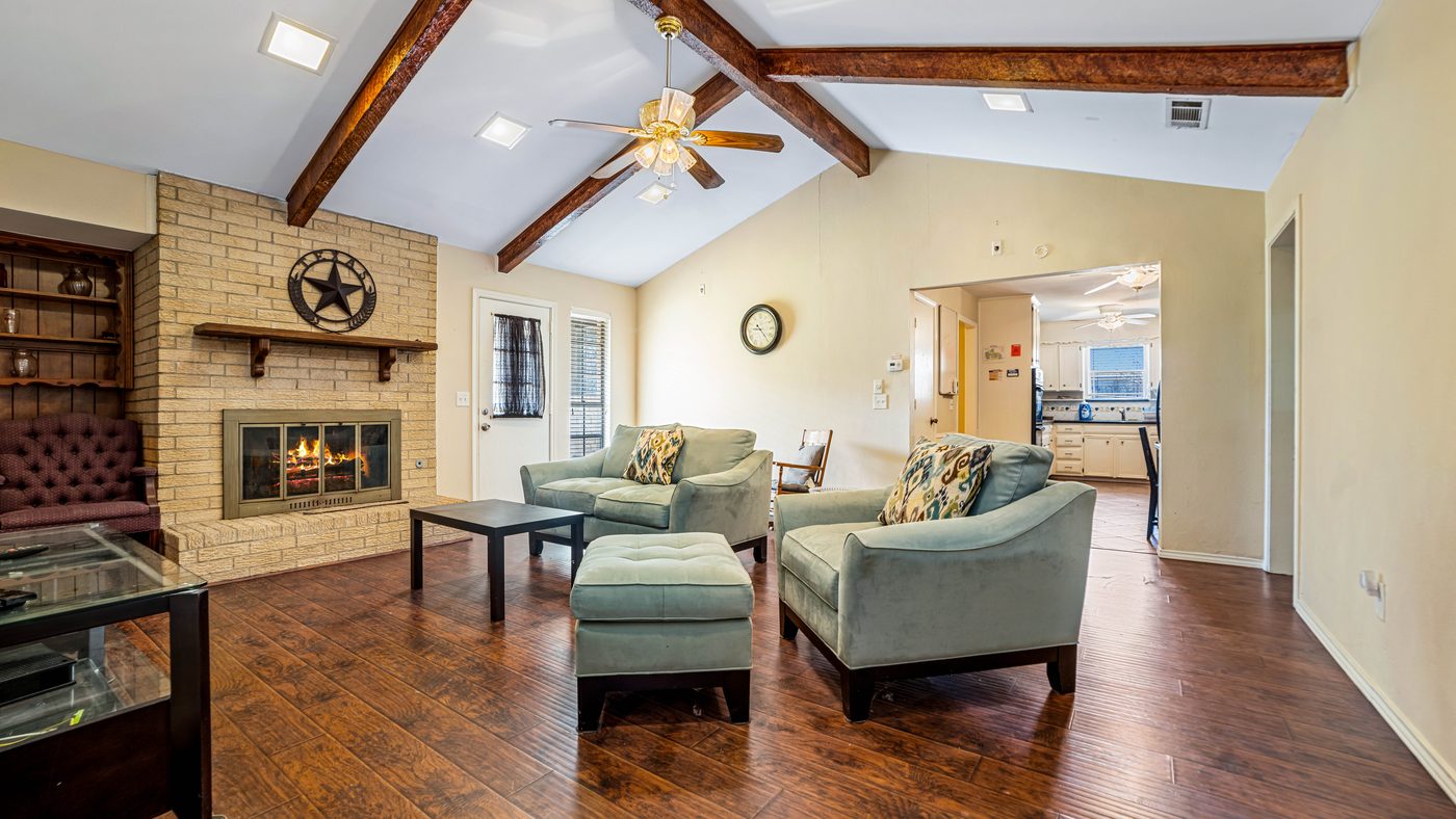 Living room with vaulted beamed ceiling and brick fireplace at Papeete