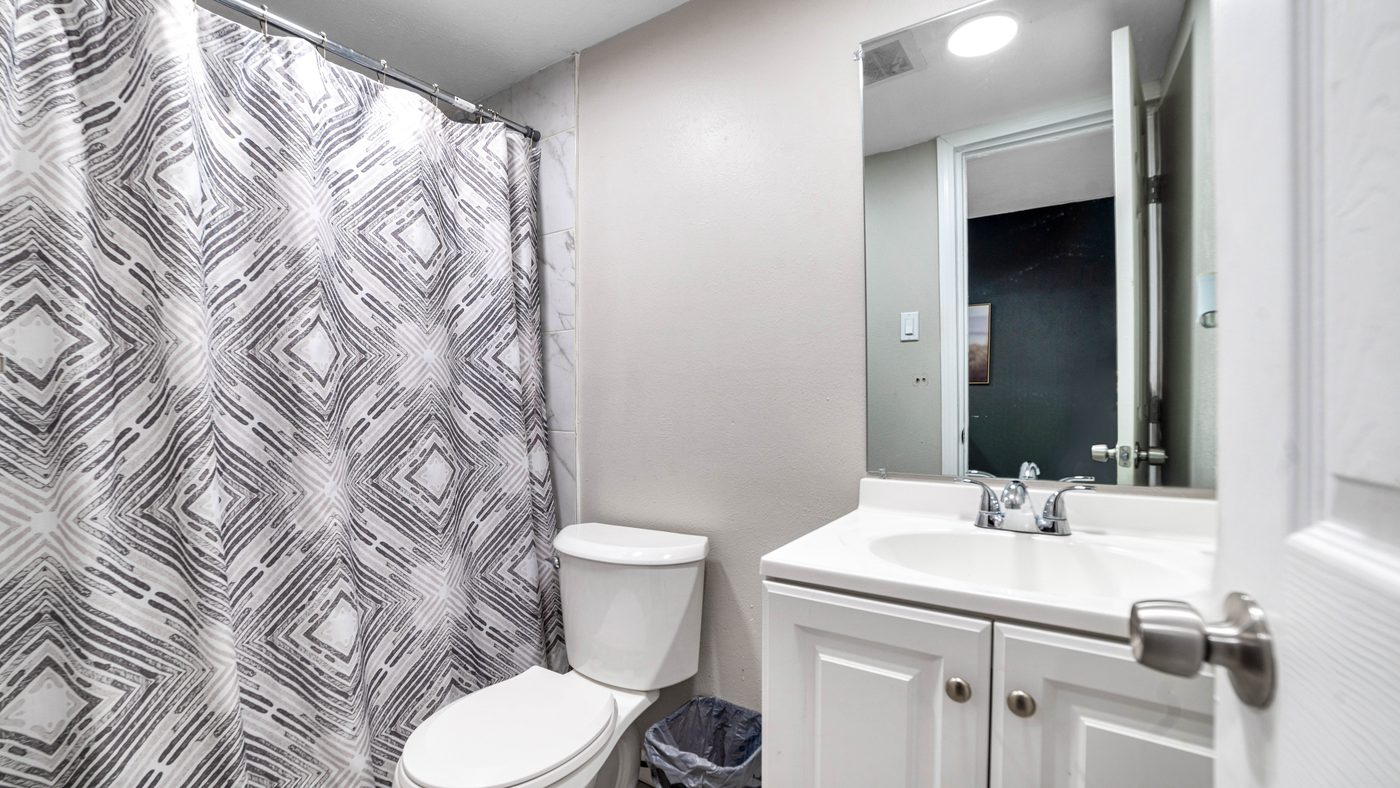 Bathroom with white vanity and patterned shower curtain at Spring Creek