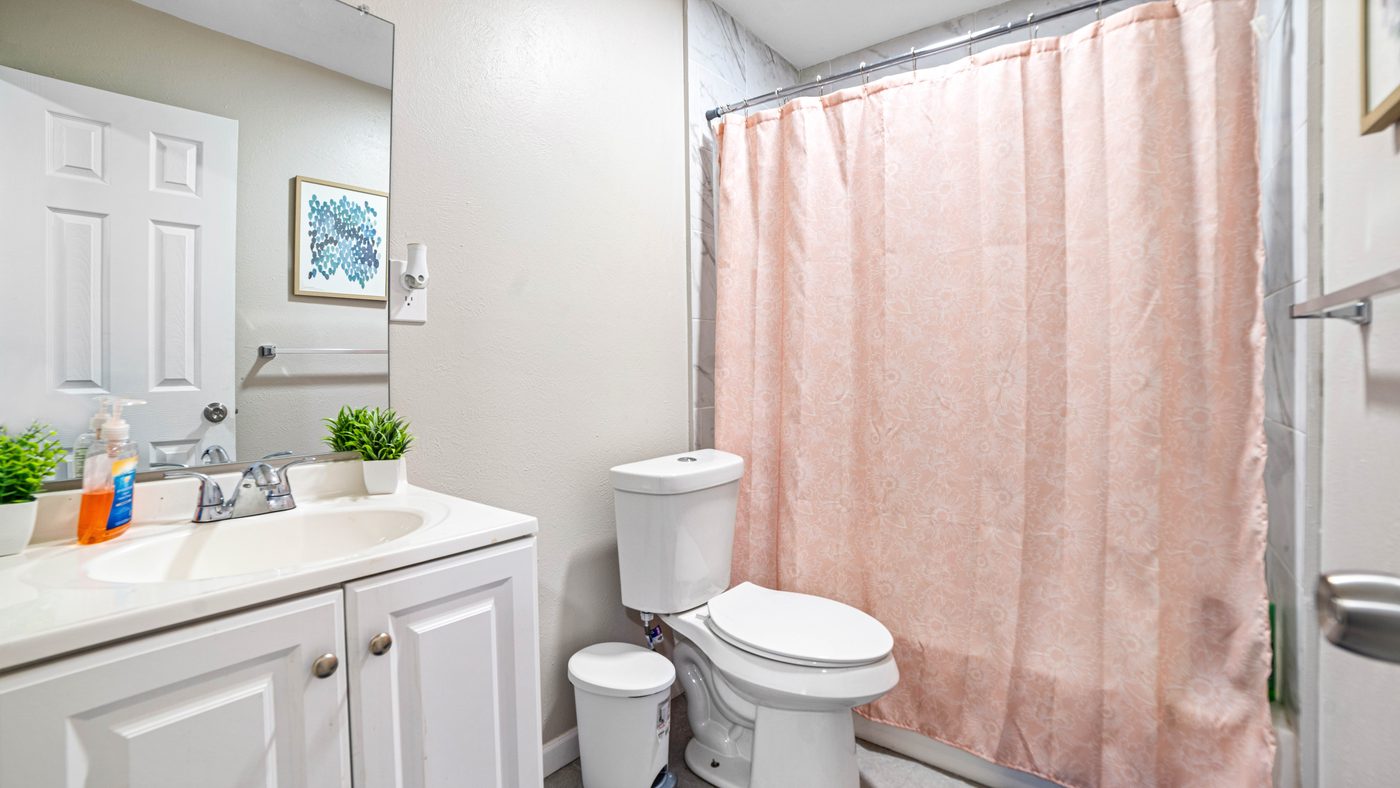 Bathroom with vanity and pink shower curtain at Spring Creek