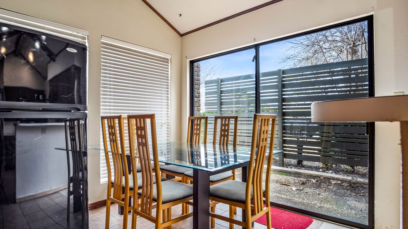 Glass dining table by a picture window at Stain Glass