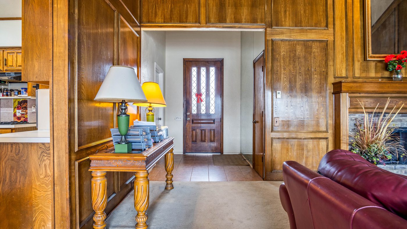 Wood-paneled entry with console table at Stain Glass