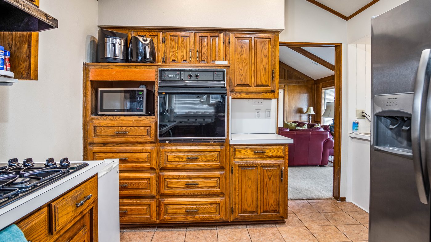 Kitchen with wall oven, gas cooktop and stainless refrigerator at Stain Glass