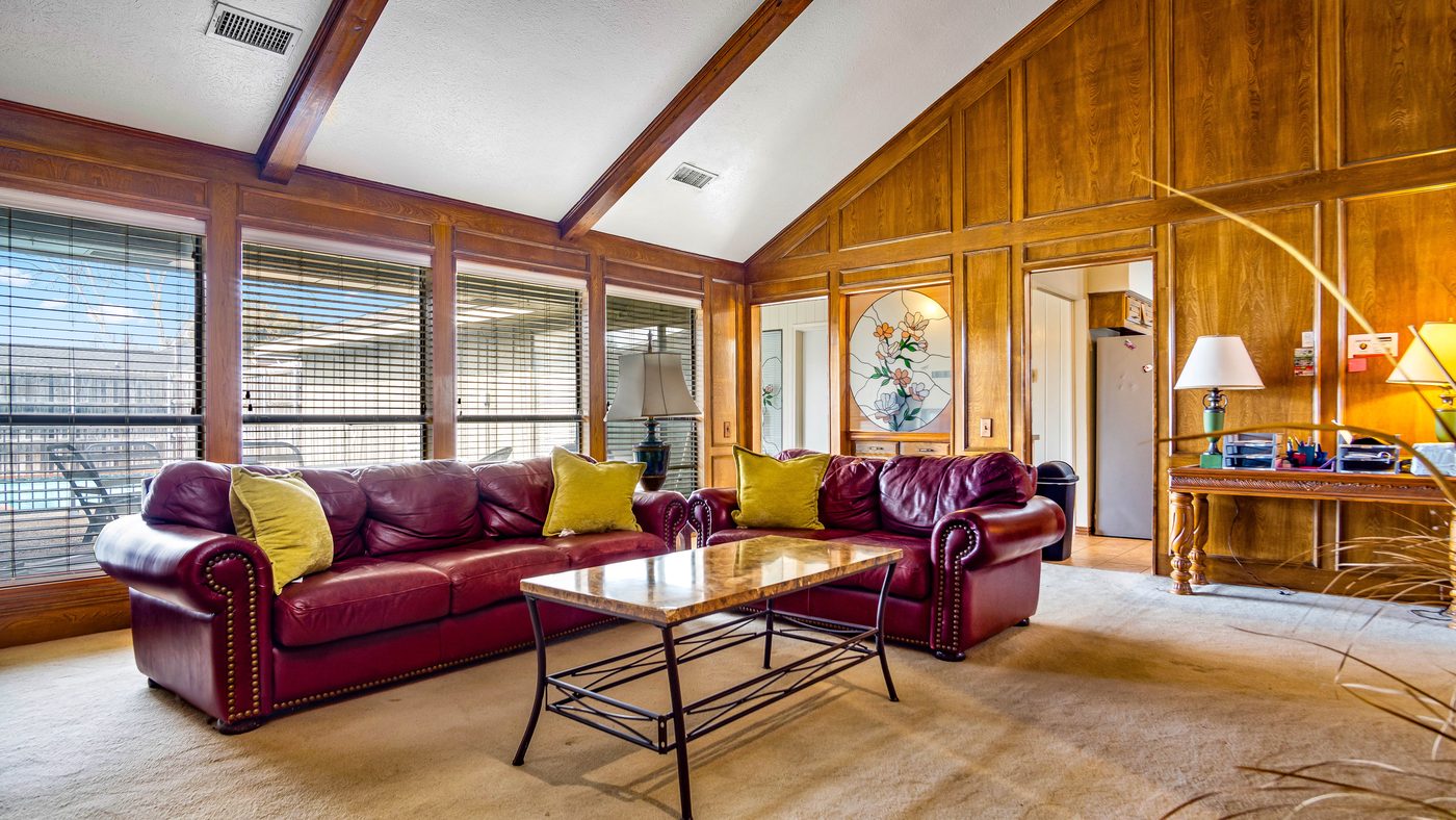 Living room with red leather sofas and vaulted ceiling at Stain Glass