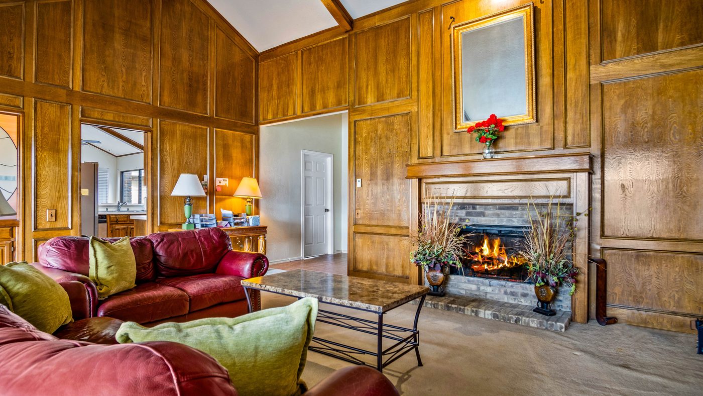 Living room fireplace and wood paneling at Stain Glass