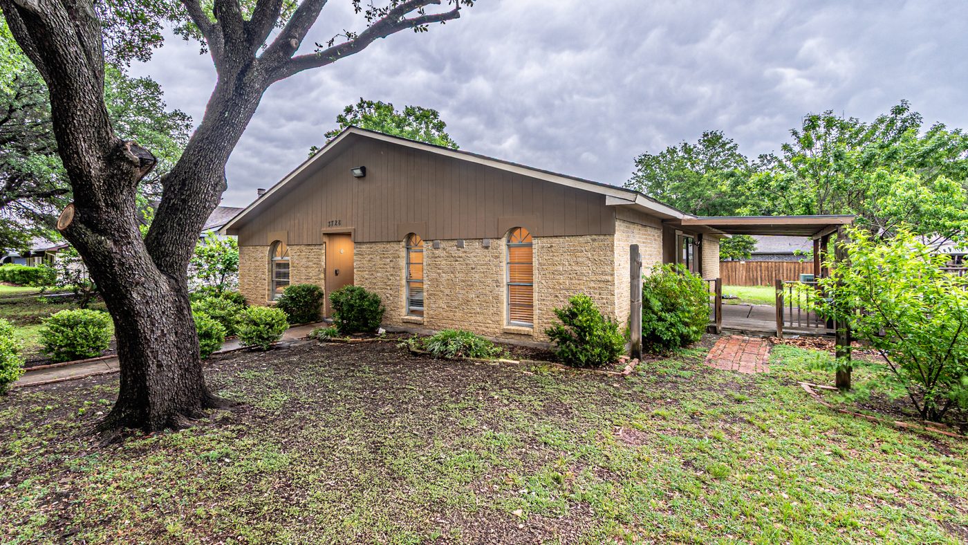 Brick and wood-sided front of Yosemite under a large oak