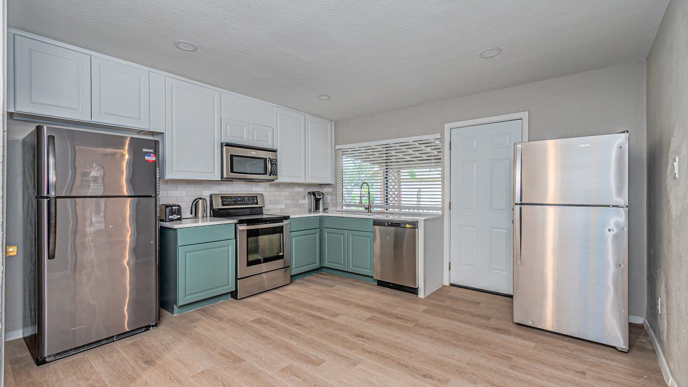 Kitchen with green lower cabinets and stainless appliances at Yosemite