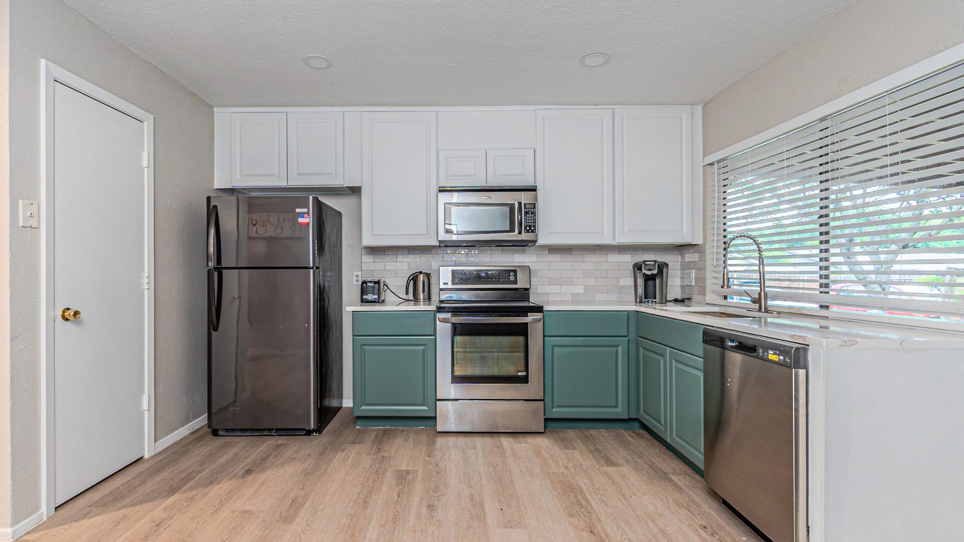 Kitchen with white upper cabinets and tile backsplash at Yosemite